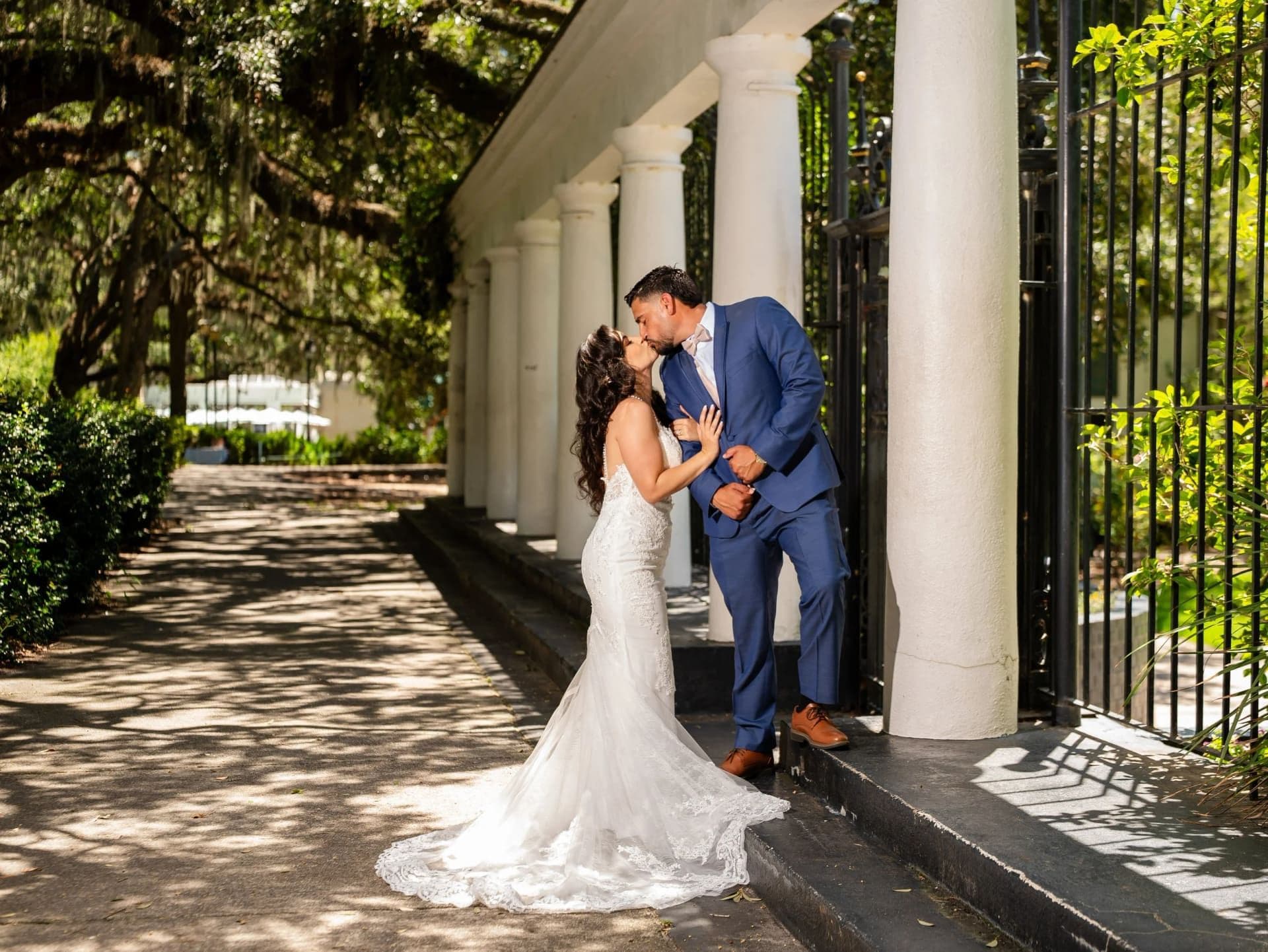 Couple eloping in Savannah, Georgia under draped Spanish moss in a historic square — all-inclusive Savannah elopement package by Elopements Inc.
